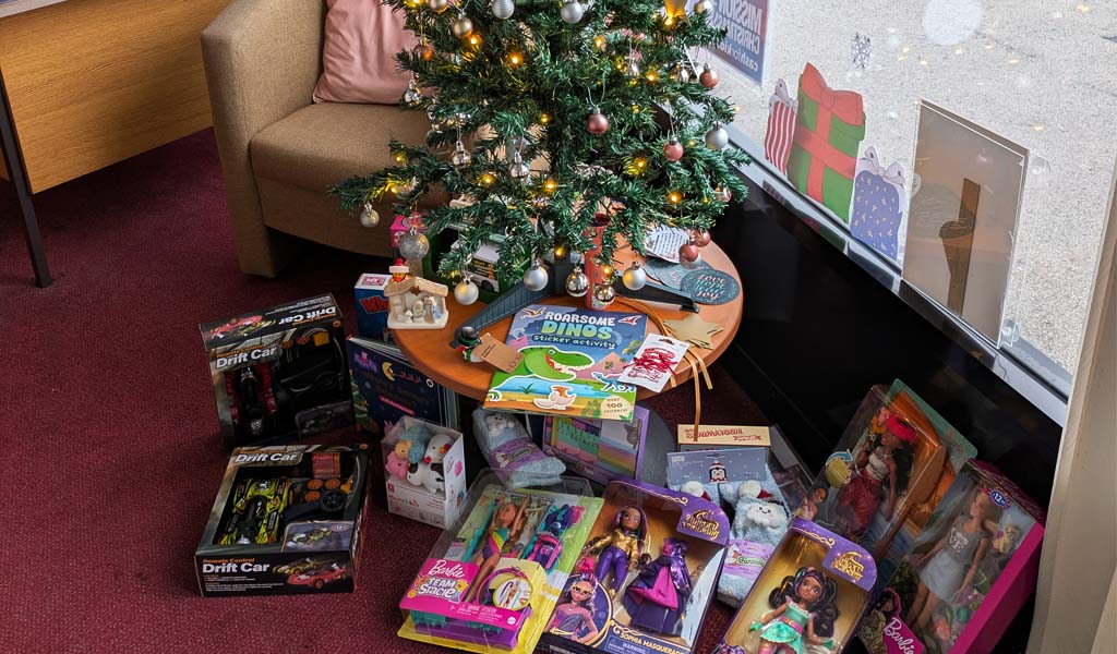 Numerous toys are put under G H Dovener & Son's Christmas Tree for Cash for Kids Mission Christmas Toy Appeal.